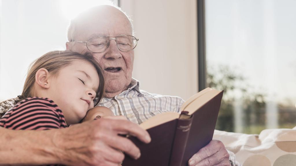 Grandfather reading out story for his granddaughter model released Symbolfoto property released PUBLICATIONxINxGERxSUIxAUTxHUNxONLY UUF09572