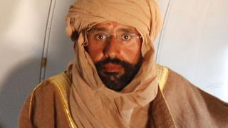 Saif al-Islam Gaddafi is pictured sitting in a plane in Zintan November 19, 2011. Saif al-Islam Gaddafi, who was captured in Libya's rugged desert, transformed himself during this year's uprising from a relaxed reformer to a belligerent and loyal lieutenant of his father who is now wanted by the ICC accused of crimes against humanity. In his final days on the run, witnesses said Saif al-Islam, 39, was nervous, confused and frightened, at first calling his father by satellite phone, swearing aides to secrecy about his whereabouts and, after his father was killed, seeking to avoid a similarly gruesome fate.   REUTERS/Ismail Zitouny  (LIBYA - Tags: POLITICS CIVIL UNREST)