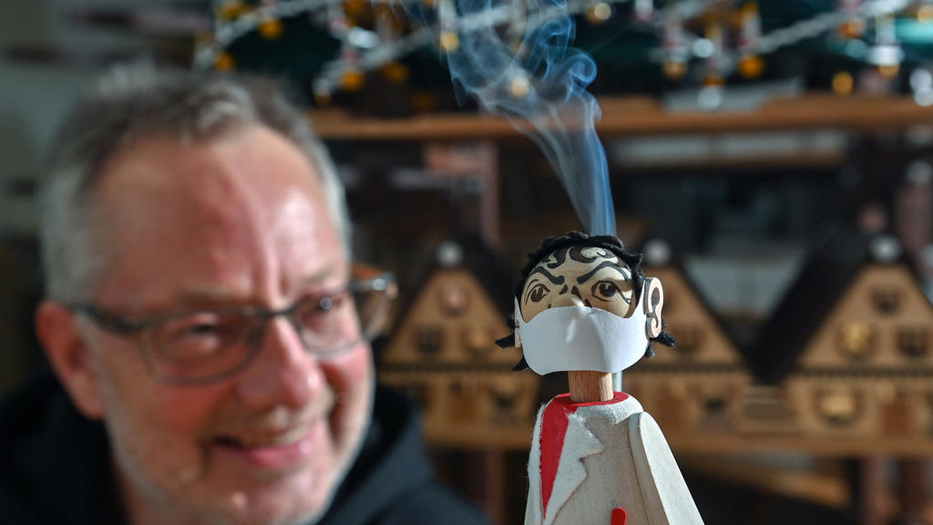 dpatopbilder - 17.11.2020, Sachsen, Seiffen: In der Werkstatt des Spielzeugmachers Tino Günther in Seiffen raucht der neuesten Figur des Sortiments der Kopf. Der Virologen-Räuchermann mit seinem Mund-Nasen-Schutz erinnert stark an den Charité-Virolog