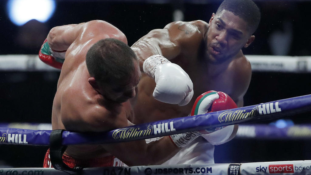 World Heavyweight boxing champion Britain's Anthony Joshua lands a blow on challenger Bulgaria's Kubrat Pulev during their Heavyweight title fight at Wembley Arena in London Saturday, Dec. 12, 2020. (Andrew Couldridge/Pool via AP)