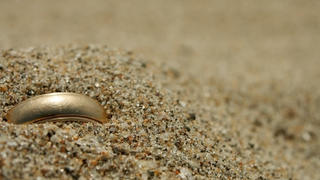 Goldring im Sand