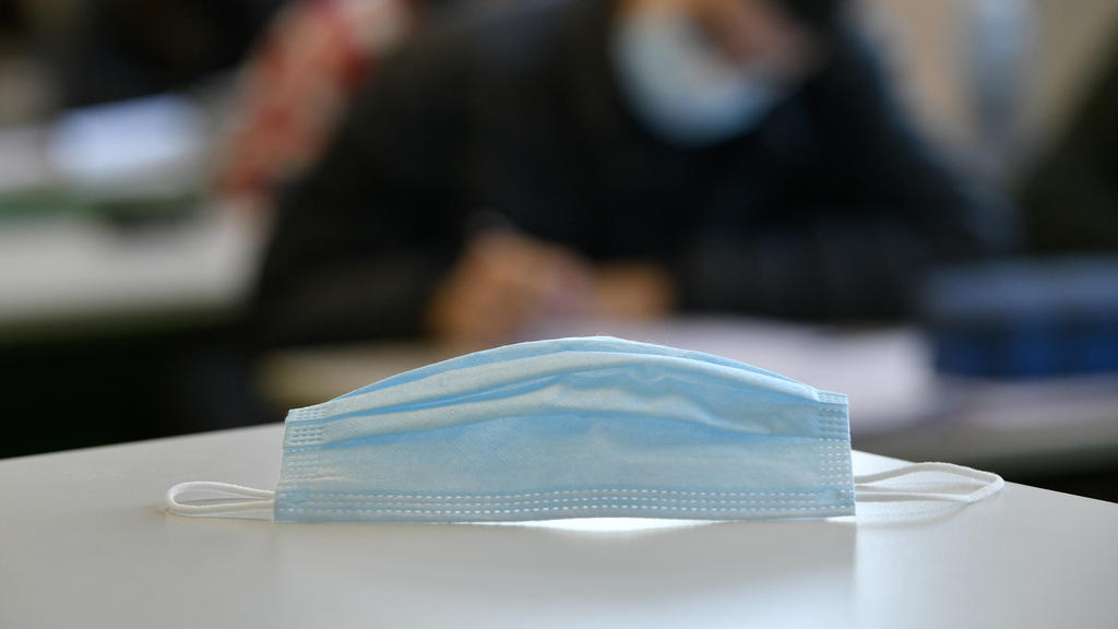 Mundschutzmaske auf Schülertisch, Präsenzunterricht, Corona-Krise, Stuttgart, Baden-Württemberg, Deutschland Coronavirus *** Face mask on students desk, classroom teaching, Corona crisis, Stuttgart, Baden Württemberg, Germany Coronavirus