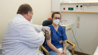 Kanzleramtschef Helge Braun impft eine Krankenschwester.