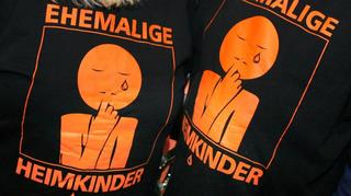 "Ehemalige Heimkinder" ist auf zwei T-Shirts zu sehen