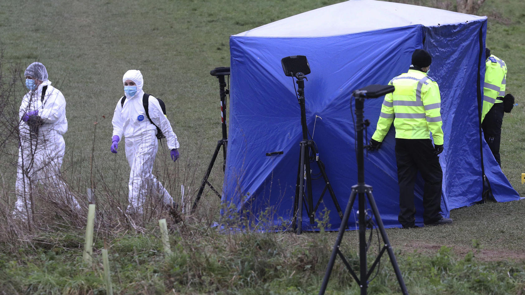 Police forensic officers attend the scene where a 13-year old boy died after being stabbed on Sunday, at the Bugs Bottom field in Reading, England, Monday Jan. 4, 2021.  The police have said five teenagers aged between 13 and 14 are being held in con