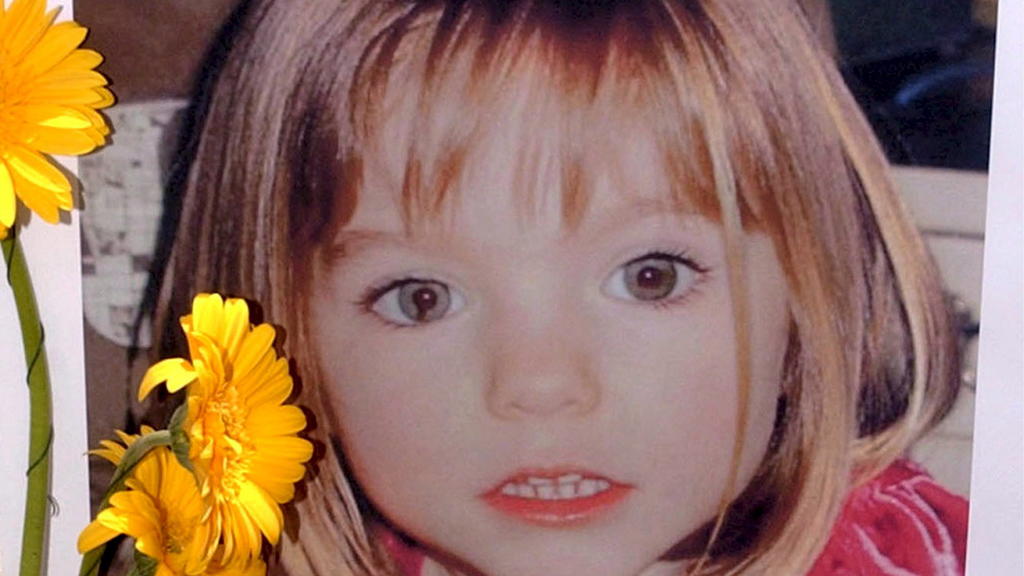 ARCHIV - 12.05.2007, Portugal, Lagos: Blumen stehen vor einem Bild, das die verschwundenen Madeleine McCann (Maddie) auf einem Foto zeigt, das ihre Eltern im Zusammenhang mit dem Verschwinden des Kindes veröffentlich haben. Im Fall der vor mehr als 1