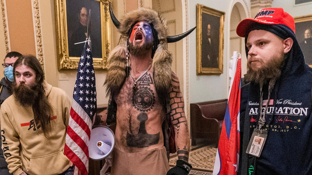 Jake Angeli aka "Q Shaman" (Q-Schamane) und andere Mitglieder der rechtsextremen QAnon-Bewegung beim Sturm auf das Kapitol in Washington.