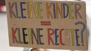 ARCHIV - 29.04.2020, Hessen, Frankfurt/Main: Ein Kind hält ein Plakat mit der Aufschrift «Kleine Kinder, Kleine Rechte?» bei einem Protest auf dem Römerberg. (zu dpa «Umfrage: Deutliche Mehrheit für Kinderrechte im Grundgesetz») Foto: Boris Roessler/dpa +++ dpa-Bildfunk +++