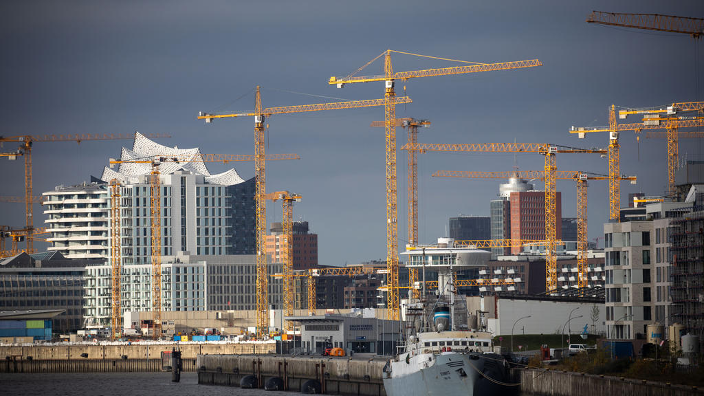 ARCHIV - 16.11.2020, Hamburg: Baukräne stehen an verschiedenen Baustellen am Bakenhafen und im Überseequartier in der Hafencity, im Hintergrund ist die markante Dachsilhouette der Elbphilharmonie zu sehen. (Zu dpa: «Bau weiterhin von Pandemie unbeein