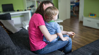 ARCHIV - 01.07.2016, Nordrhein-Westfalen, Dortmund: Eine Mutter sitzt mit ihrem Sohn auf dem Schoß auf einer Couch. Die verschärften Corona-Regeln in Schulen und Kitas treffen Familien und vor allem alleinerziehende Mütter und Väter hart.(zu dpa «Corona-Auflagen: Alleinerziehende fordern Klarheit über Betreuung») Foto: Marcel Kusch/dpa +++ dpa-Bildfunk +++
