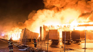 13.01.2021, Hamburg: Feuerwehrleute löschen im Stadtteil Wilhelmsburg ein Großbrand. Eine Lagerhalle in einem Gewerbegebiet steht seit dem Morgen im Vollbrand. Foto: Daniel Bockwoldt/dpa +++ dpa-Bildfunk +++