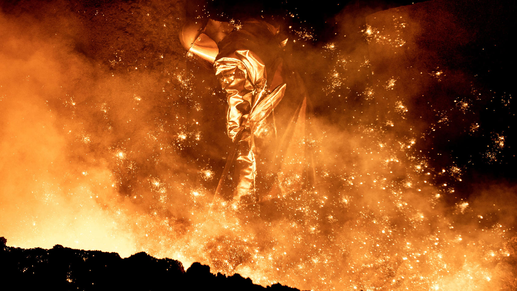 ARCHIV - 02.03.2020, Niedersachsen, Salzgitter: Ein Mitarbeiter reinigt in einem Stahlwerk die Abstichrinne am Hochofen. Mit der Erholung der deutschen Wirtschaft vom Corona-Einbruch im Frühjahr ist auch die Beschäftigung in der Industrie wieder gest