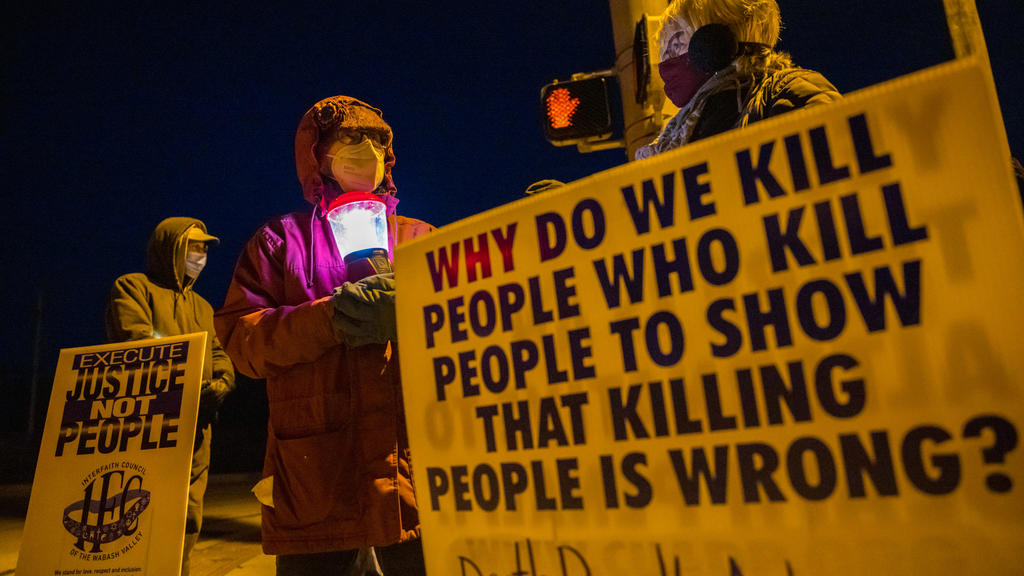 12.01.2021, USA, Bloomington: Glenda Breeden (M) aus Bloomington, Aktivistin gegen die Todesstrafe, hält eine Lampe, bei einem Protest gegen die Hinrichtung von Lisa Montgomery und zwei weiteren Personen im Gefängnis in Terre Haute im US-Bundesstaat