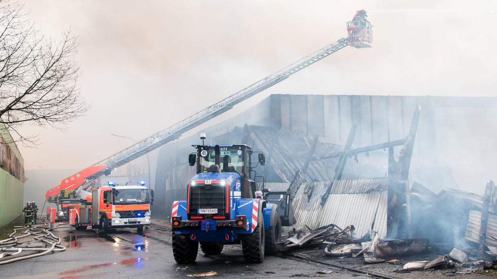 13.01.2021, Hamburg: Feuerwehrleute löschen im Stadtteil Wilhelmsburg einen Großbrand mit Hilfe eines Radladers des THW. Eine Lagerhalle in einem Gewerbegebiet steht seit dem Morgen im Vollbrand. Foto: Daniel Bockwoldt/dpa +++ dpa-Bildfunk +++