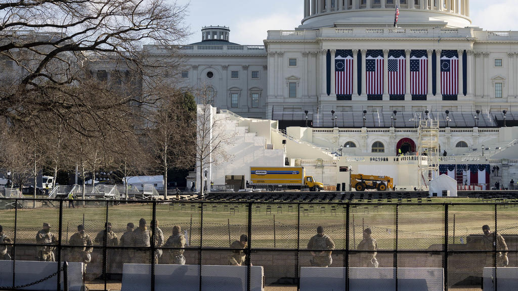 13.01.2021, USA, Washington: Mitglieder der Nationalgarde sichern das Gebiet um das US-Kapitol, vor dem die Aufbauarbeiten für die Zeremonie zur Amtseinführung des gewählten US-Präsidenten Biden stattfinden. Das Repräsentantenhaus hat mit der Beratun