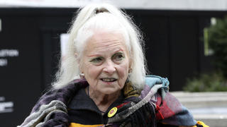 British designer Vivienne Westwood holds a ball with the writing Justice on it as she arrives at a London Court ahead of a hearing on the extradition to the United States of Wikileaks founder Julian Assange, in London, Monday, Sept. 7, 2020. Lawyers for Assange and the U.S. government will face off in London on Monday at an extradition hearing that was delayed by the coronavirus pandemic. (Jonathan Brady/PA via AP)