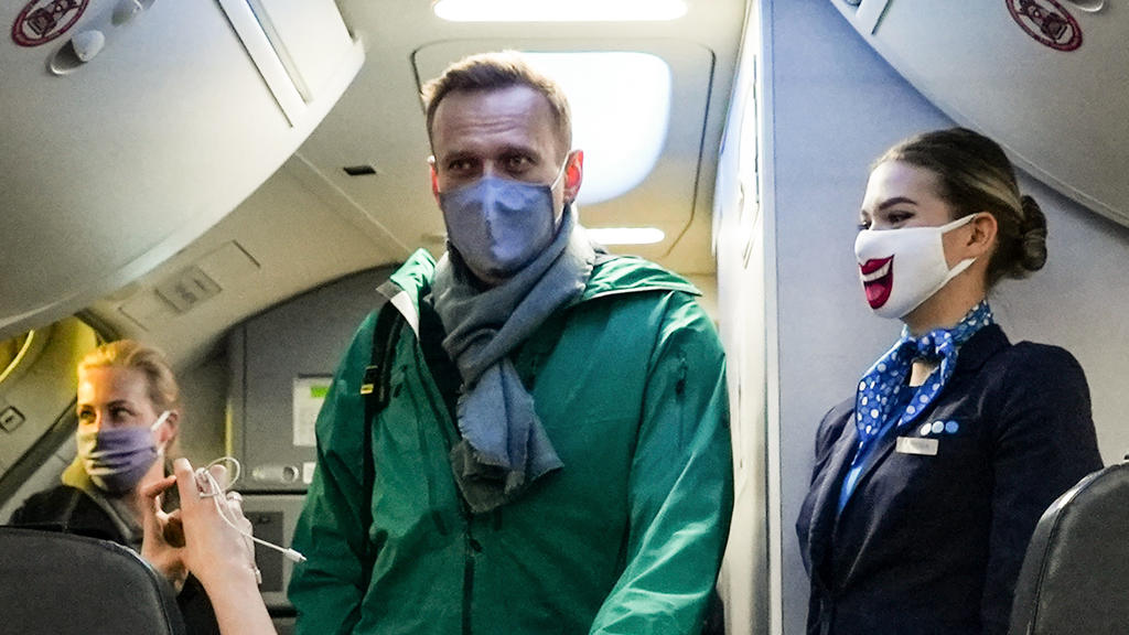 17.01.2021, Schönefeld: Alexei Nawalny und seine Ehefrau Julia (l) besteigen ein Flugzeug der Fluggesellschaft «Pobeda», mit dem Nawalny von Berlin Schönefeld aus nach Moskau fliegen will. Nawalny hielt sich für die Behandlung nach seiner Vergiftung
