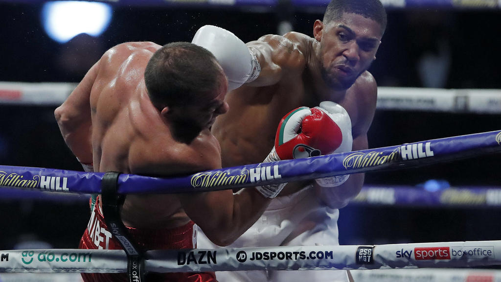 World Heavyweight boxing champion Britain's Anthony Joshua lands a blow on challenger Bulgaria's Kubrat Pulev during their Heavyweight title fight at Wembley Arena in London Saturday, Dec. 12, 2020. (Andrew Couldridge/Pool via AP)