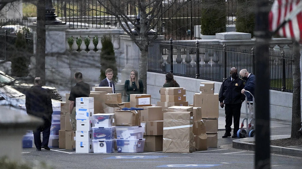 FILE - In this Jan. 14, 2021, file photo people wait for a moving van after boxes were moved out of the Eisenhower Executive Office building inside the White House complex in Washington. The public won’t see President Donald Trump’s White House r