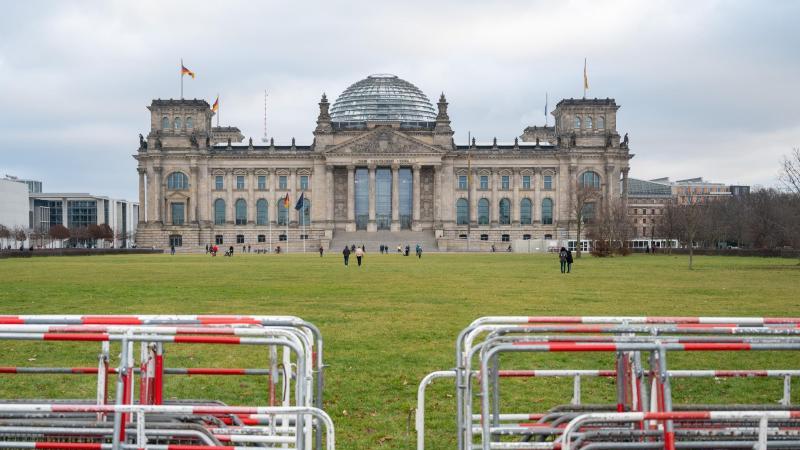 Auf der Wiese vor dem Reichstagsgebäude stehen Absperrgitter. Foto: Christophe Gateau/dpa