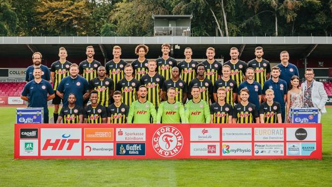 Steffi und Deniis Schick posieren gemeinsam mit dem Fußballverein "SC Fortuna Köln"