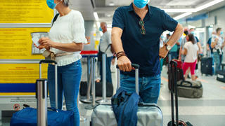 Mann und Frau mit Corona-Masken am Flughafen
