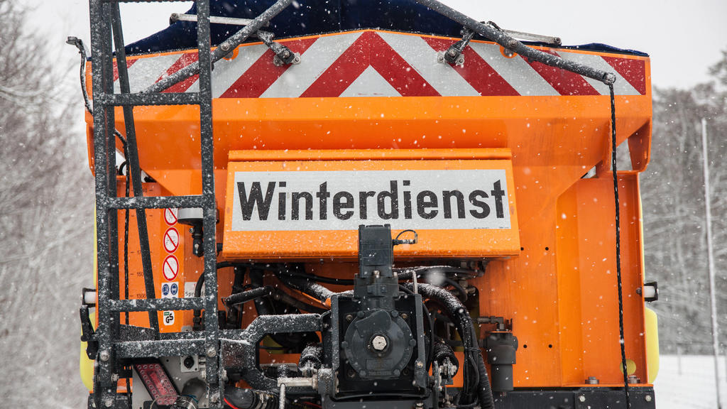 Bamberg, Deutschland 24. Januar 2021: Ein Streufahrzeug vom Winterdienst ist im Winter auf einer mit Schnee bedeckten Strasse unterwegs. Bayern *** Bamberg, Germany 24 January 2021 A gritting vehicle from the winter road maintenance service is on th