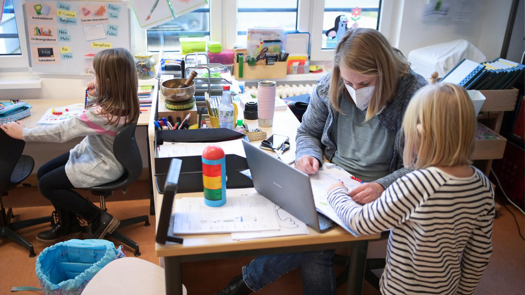 21.01.2021, Brandenburg, Oranienburg: Die Lehrerin Kerstin Alter und eine Schülerin unterhalten sich in der Comenius-Schule während einer Schulstunde der ersten Klassen. Die integrative Grundschule mit Sprachfördergruppen war vor fünf Jahren nach Ora
