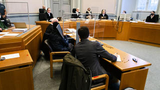 ARCHIV - 09.12.2020, Schleswig-Holstein, Kiel: Prozessteilnehmer sitzen im Schwurgerichtssaal im Landgericht Kiel. Mittig im Hintergrund sitzt der Vorsitzende Richter Carsten Tepp. Einem 53-jährigen Mann sowie dessen Ehefrau und seiner 87-jährigen Mutter wird vorgeworfen, 14 Lebens- und Unfallversicherungen in Höhe von rund 4,1 Millionen Euro abgeschlossen zu haben. Um an die Versicherungssummen zu kommen, soll der Mann im Oktober 2019 ein Bootsunglück und seinen Tod vorgetäuscht haben. Im Mai 2020 nahmen Polizisten den 53-Jährigen auf dem Dachboden im Haus seiner Mutter im niedersächsischen Schwarmstedt fest. Foto: Frank Molter/dpa +++ dpa-Bildfunk +++