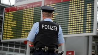  Ein Beamter der Bundespolizei steht am Flughafen Dresden International im Bereich des Check-In vor der elektronischen Anzeigetafel.