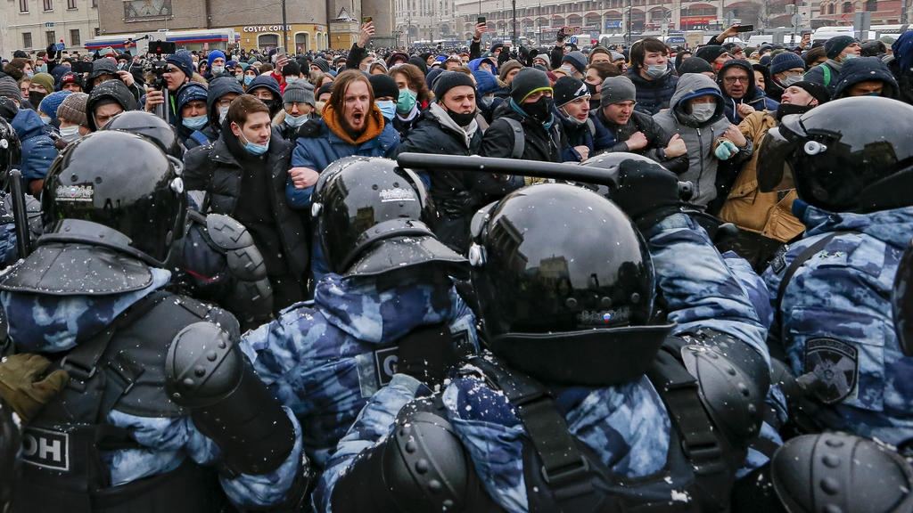 31.01.2021, Russland, Moskau: Polizisten in Schutzkleidung blockieren Demonstranten den Weg bei einem Protest gegen die Inhaftierung des Kremlkritikers Nawalny. Tausende von Menschen gingen in ganz Russland auf die Straßen um die Freilassung Nawalnys