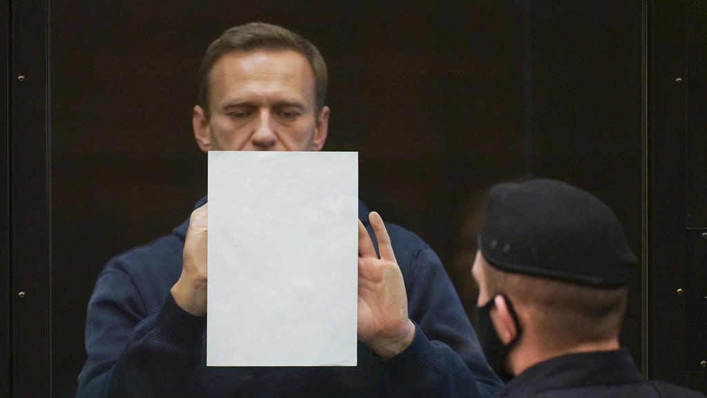 HANDOUT - 02.02.2021, Russland, Moskau: In diesem Handout-Foto, das vom Moskauer Stadtgericht zur Verfügung gestellt wurde, hält der russische Oppositionsführer Alexej Nawalny ein Dokument im Käfig stehend bei einer Anhörung zu einem Antrag des russi