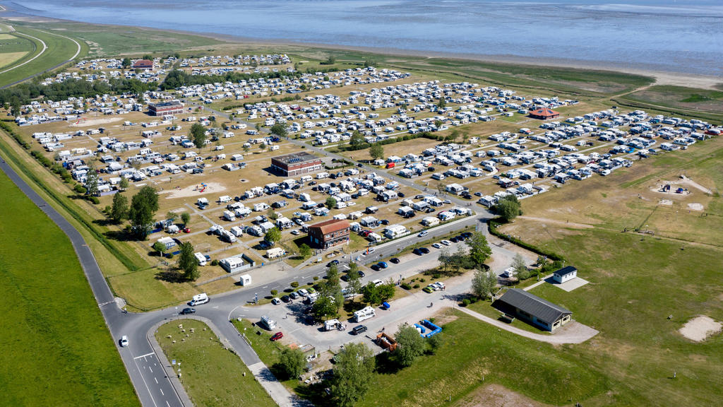 ARCHIV - 30.05.2020, Niedersachsen, Hooksiel: Wohnmobile und Wohnwagen stehen auf dem Campingplatz des Ortes hinter dem Deich (Luftaufnahme mit Drohne). (Zu dpa "Rekordzahl bei Campingübernachtungen im Juli") Foto: Hauke-Christian Dittrich/dpa +++ dp