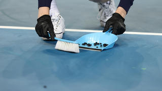 MELBOURNE, AUSTRALIA - FEBRUARY 10: Court staff sweeps insects up off Margaret Court Arena during the in her Women's Singles second round match between Simona Halep of Romania and Ajla Tomljanovic of Australia during day three of the 2021 Australian Open at Melbourne Park on February 10, 2021 in Melbourne, Australia. (Photo by Cameron Spencer/Getty Images)