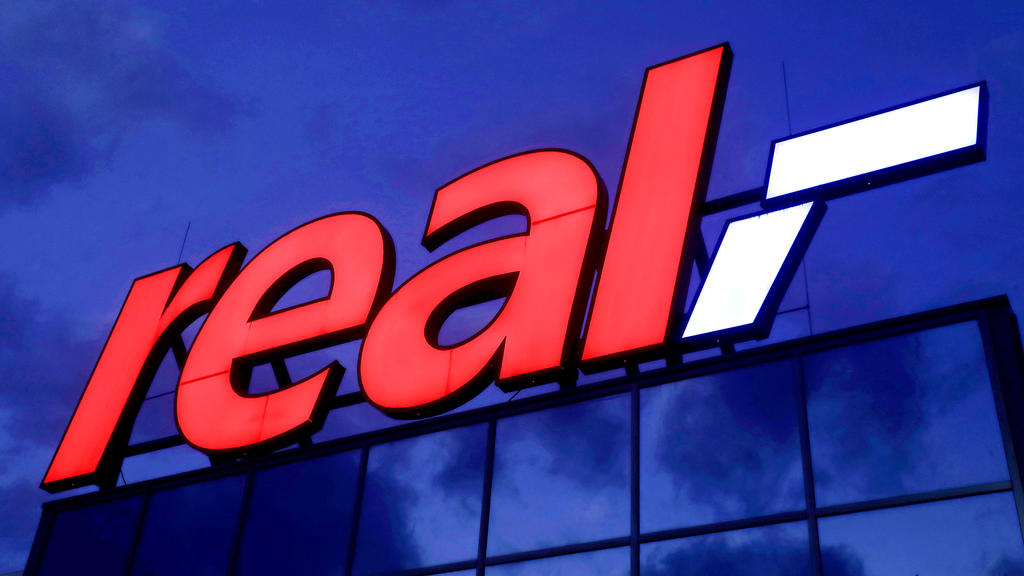 ARCHIV - 17.01.2020, Nordrhein-Westfalen, Köln: Das Logo leuchtet am Morgen auf dem Dach eines Real Warenhauses. (zu dpa "Kartellamt erlaubt Übernahme von 92 Real-Märkten durch Kaufland") Foto: Oliver Berg/dpa +++ dpa-Bildfunk +++