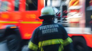 Feuerwehrmann steht vor einem Löschfahrzeug