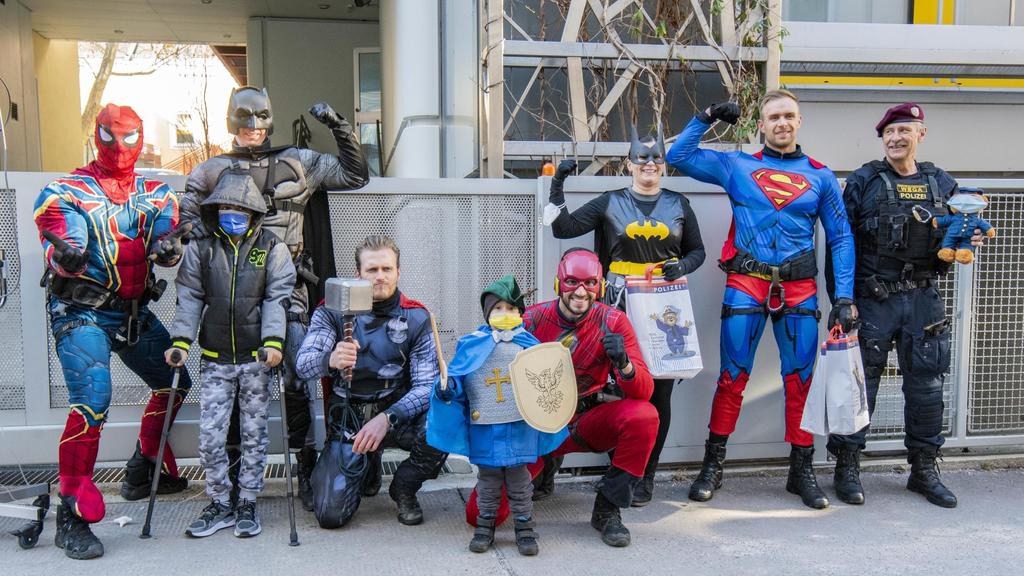 Als Superhelden verkleidete Polizisten posieren für Gruppenfoto