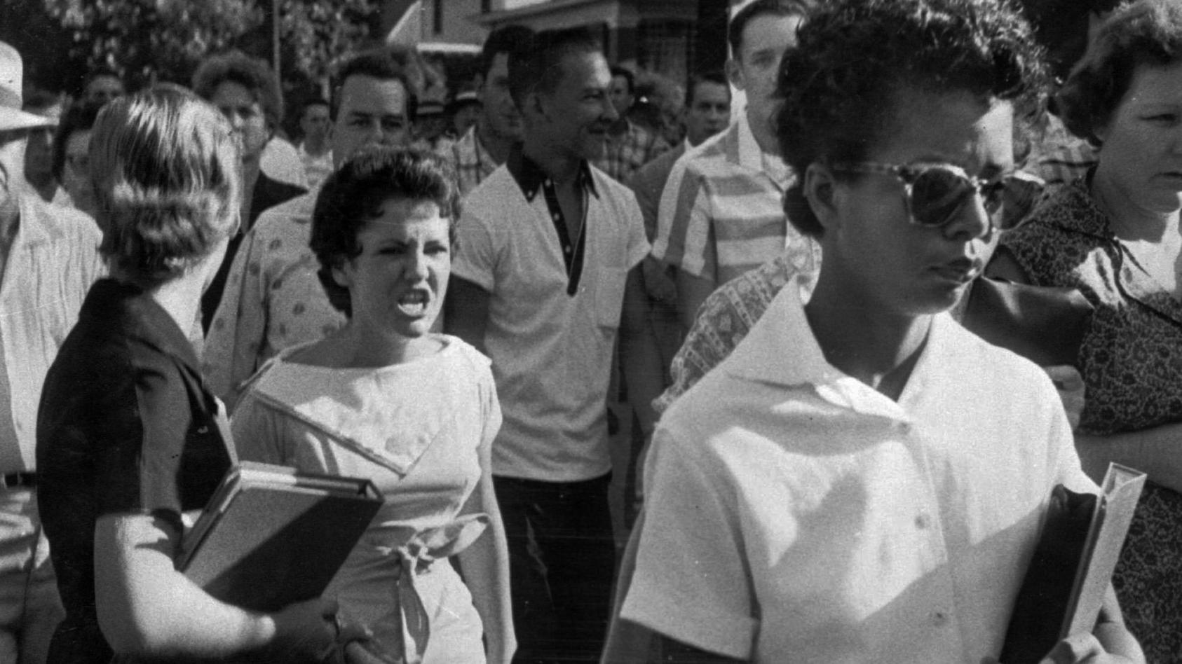 In this Sept. 4, 1957 file photo, students of Central High School in Little Rock, including Hazel Bryan, shout insults at Elizabeth Eckford as she calmly marches down to a line of National Guardsmen