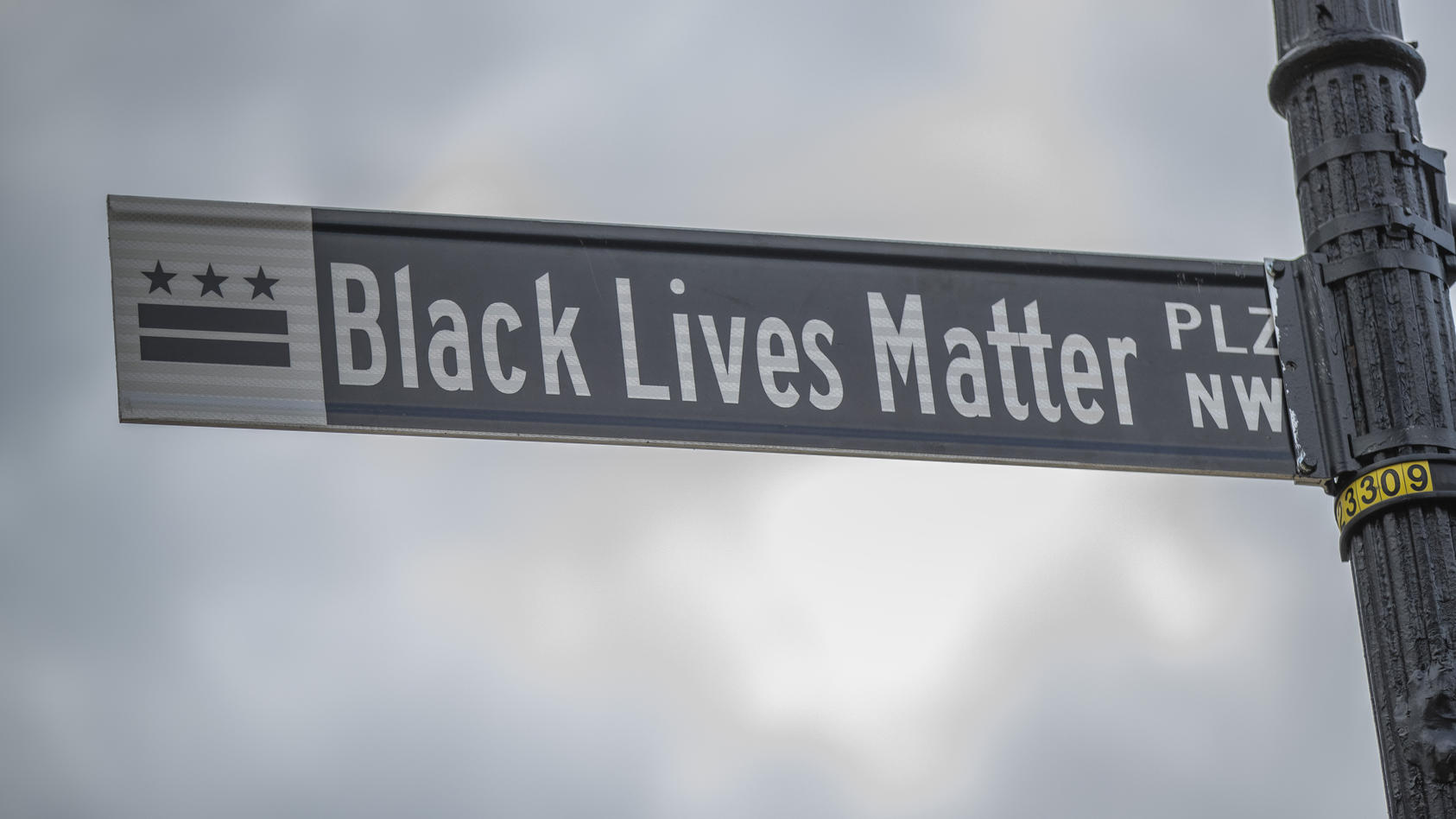 january-18-2021-washington-district-of-columbia-usa-the-black-lives-matter-plz-nw-street-sign-sits-on-a-clody-day-in-the-united-states-capital