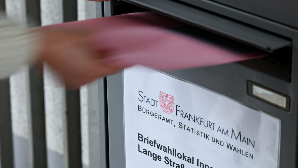 ILLUSTRATION - 05.02.2021, Hessen, Frankfurt/Main: Ein Umschlag mit Briefwahlunterlagen wird am Briefwahllokal Frankfurt Innenstadt in einen Briefkasten geworfen. Angesichts der Corona-Pandemie hat die Stadt Frankfurt schon jetzt ein großes Interesse