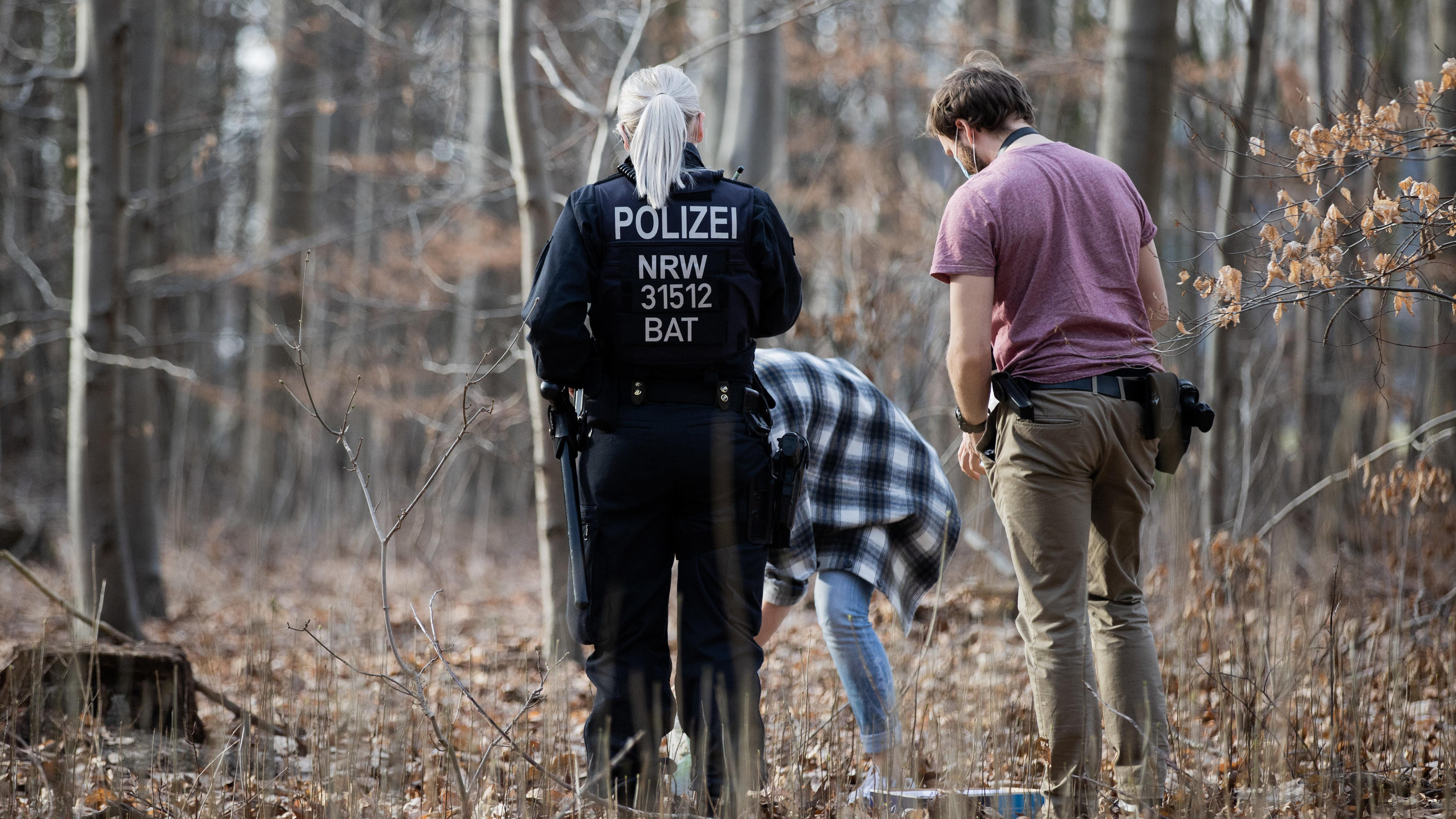 25.02.2021, Nordrhein-Westfalen, Köln: Polizeibeamte und Kriminalbeamte durchsuchen ein Waldstück im Stadtwald nach Spuren. Nach der Vergewaltigung einer Joggerin im Kölner Stadtwald befürchtet die Polizei eine Wiederholungstat. Darauf deute das atyp