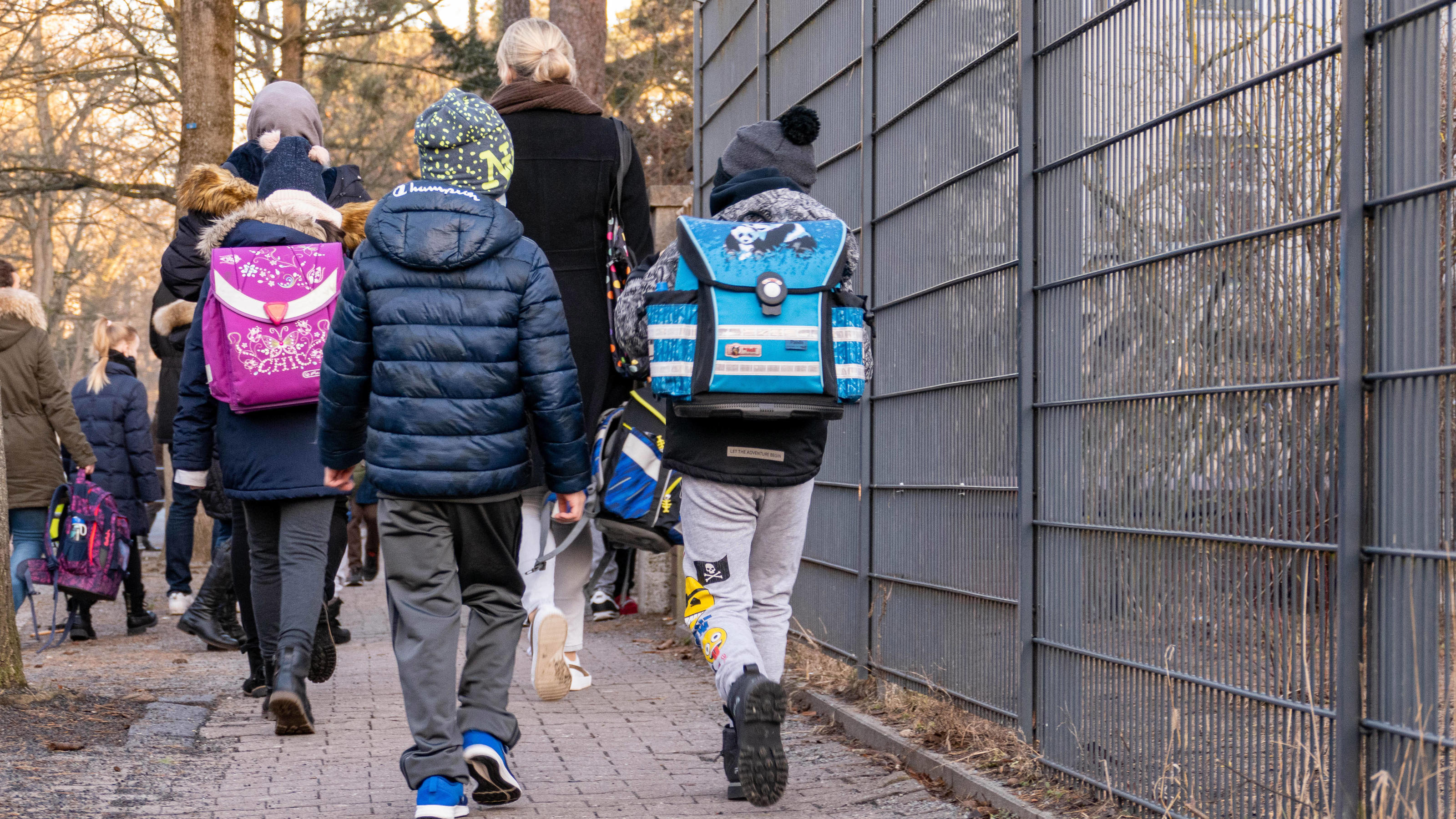 Grundschüler werden mit Erwachsenen auf ihrem Weg zur Schule begeleitet.