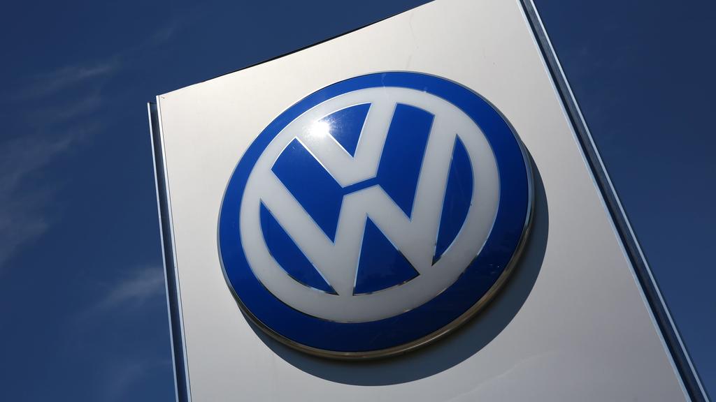 VW-Logo vor einem Volkswagenwerk in Wolfsburg
