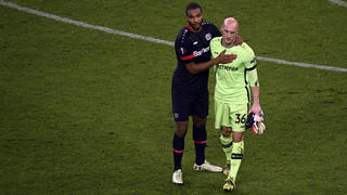 Leverkusen's Jonathan Tah, left, and Leverkusen's goalkeeper Niklas Lomb leave the field at the end of the Europa League round of 32, 2nd leg soccer match between Bayer 04 Leverkusen and Young Boys Bern in Leverkusen, Germany, Thursday, Feb. 25, 2021. (Ina Fassbender/Pool via AP)