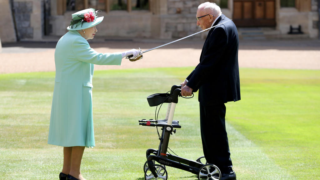 FILE PHOTO: Britain's Queen Elizabeth awards Captain Tom Moore with the insignia of Knight Bachelor at Windsor Castle, in Windsor, Britain July 17, 2020. Chris Jackson/Pool via REUTERS TPX IMAGES OF THE DAY/File Photo
