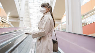  Woman with face mask and disposable gloves on an escalator in a shopping center model released Symbolfoto AHSF02593
