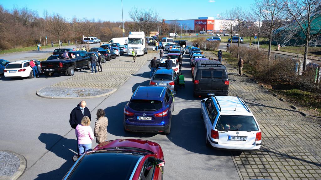 06.03.2021, Sachsen, Dresden: Zahlreiche Fahrzeuge stehen vor Beginn eines Autokorsos auf einem Parkplatz an der Autobahn 4. Kritiker der Corona-Maßnahmen haben sich am Samstagvormittag an mehreren Orten in Sachsen und Sachsen-Anhalt zu Autokorsos v