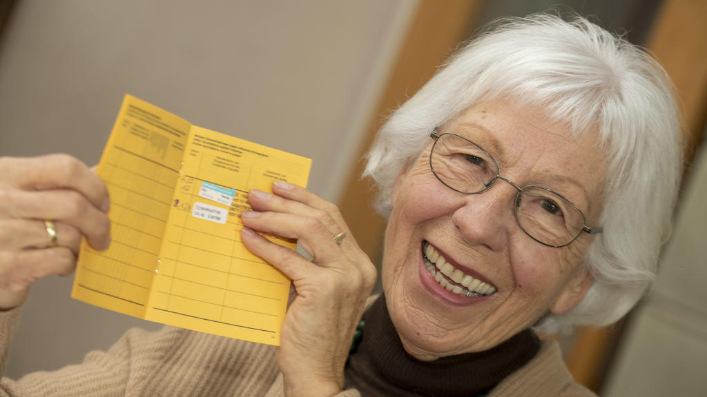 23.01.2021, Baden-Württemberg, Ulm: Seniorin Ursula Neuberger hält ihren Impfpass, in dem eine Grippe-Impfung (oben) und ihre erste Corona-Impfung vermerkt sind. Die meisten Menschen über 80 Jahre leben in Deutschland zu Hause. Sie müssen sich selbst