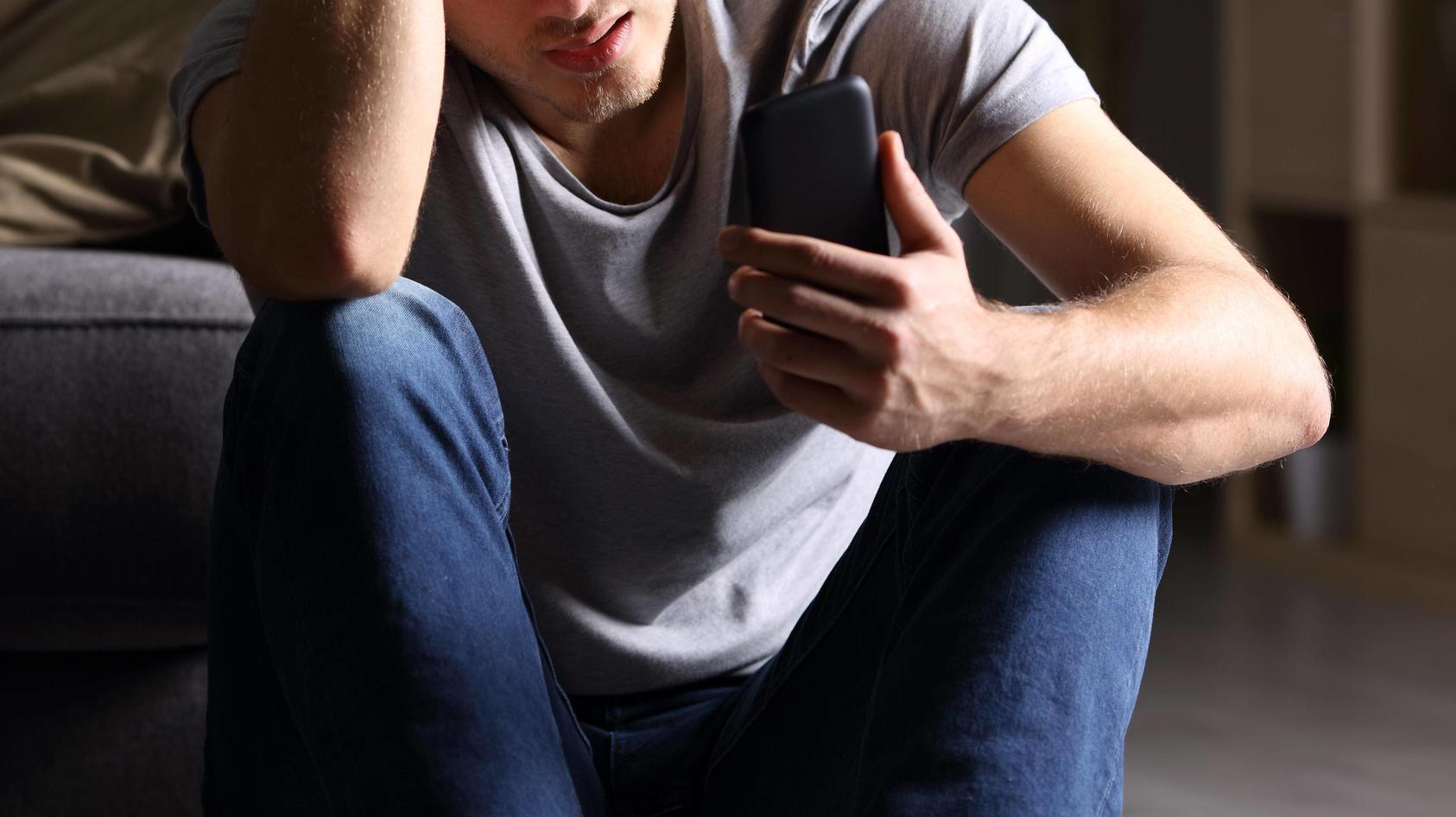  Sad man checking mobile phone ,model released, Symbolfoto PUBLICATIONxINxGERxSUIxAUTxONLY Copyright: xAntonioGuillemx Panthermedia26591660