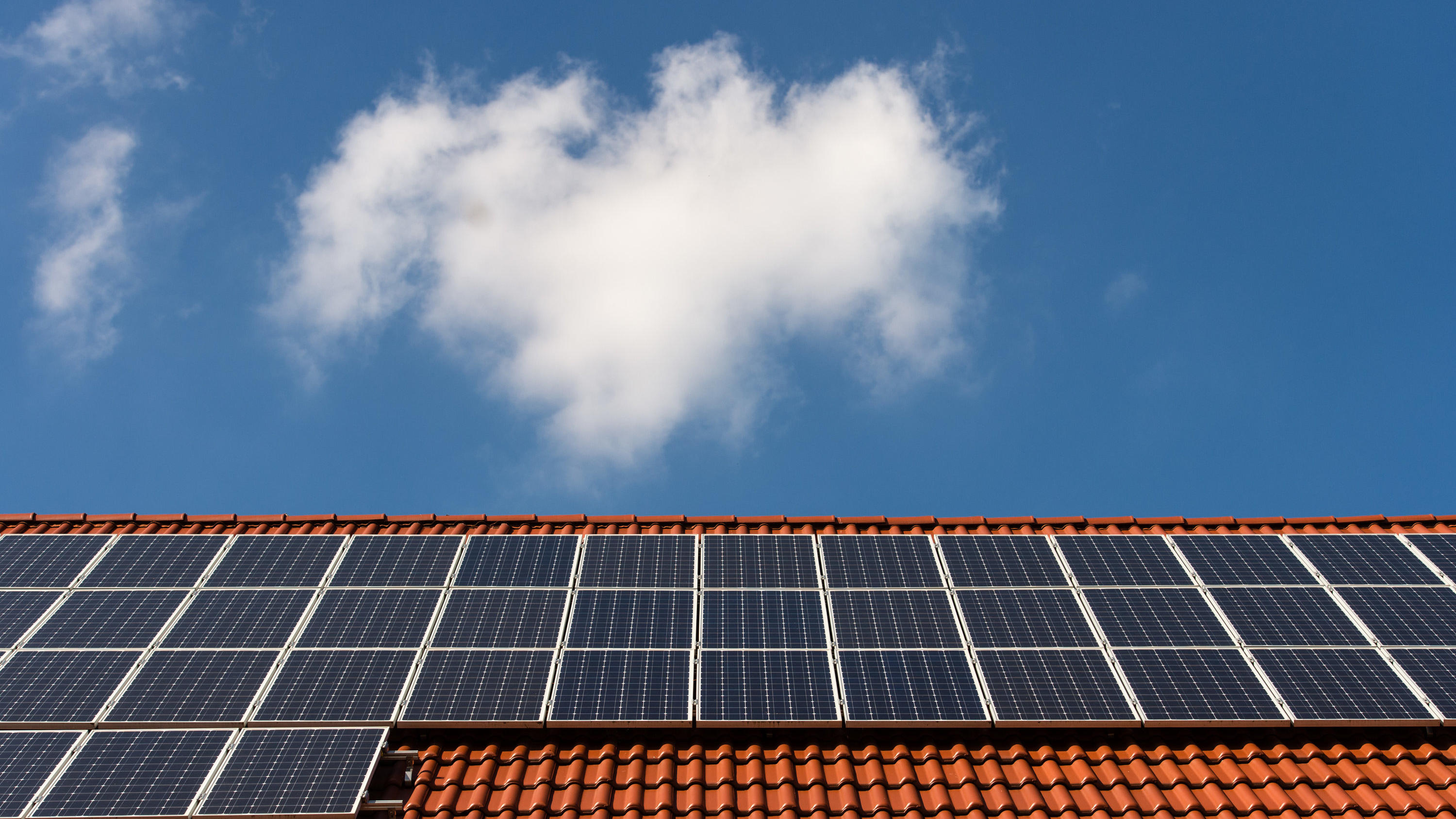 Solarzellen liegen auf einem Ziegeldach. 